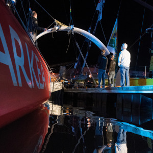 Les membres de l'équipe Arkea Paprec en train de travailler sur les foils de l'Imoca de nuit