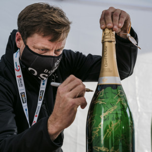  Le skipper Alex Thomson signe un magnum de champagne Canard Duchene avant son dernier test PCR 